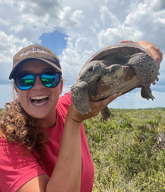 Grace Campbell, wildlife biologist for Lykes Bros. Inc. with gopher tortoise.